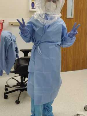 Dr Zeest Khan wearing a protective gown and gloves.