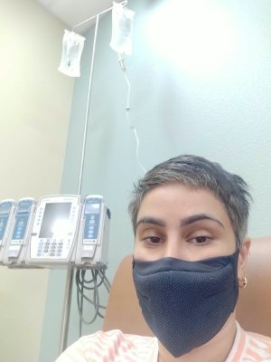 Dr Zeest Khan wearing a mask beside medical equipment.