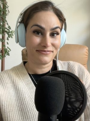Dr Zeest Khan wearing headphones while working at a laptop.