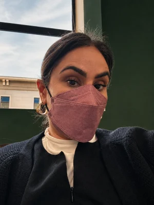 Dr Zeest Khan wearing a pink mask indoors.