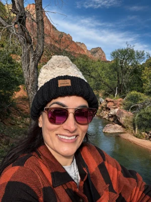 Dr Zeest Khan outdoors wearing a knitted hat and sunglasses.